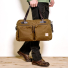 Filson 48-Hour Tin Cloth Duffle Bag Dark Tan wearing in hand