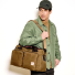 Filson 48-Hour Tin Cloth Duffle Bag Dark Tan wearing on shoulder