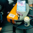 Topo Designs Quick Pack Beetle/Spice lifestyle on table