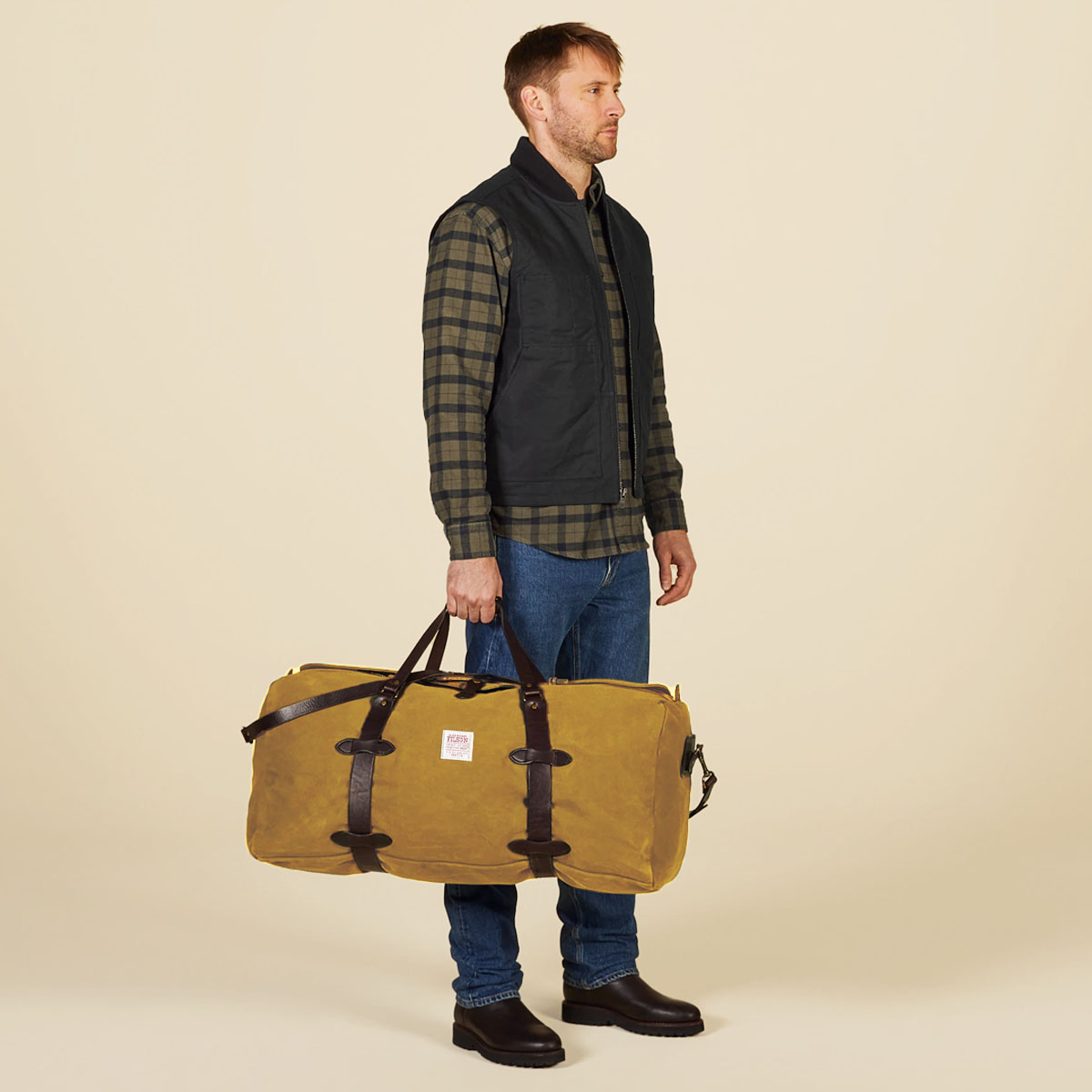 Filson Rugged Twilll Duffle Bag Large Tan, in der Hand getragen