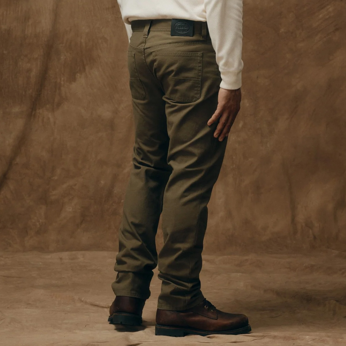 Filson Dry Tin 5 Pocket Pants Marsh Olive, Lockerer Sitz an Gesäß und Oberschenkeln mit geradem Bein. Etwas größer geschnitten als andere Filson-Hosen für bessere Bewegungsfreiheit.